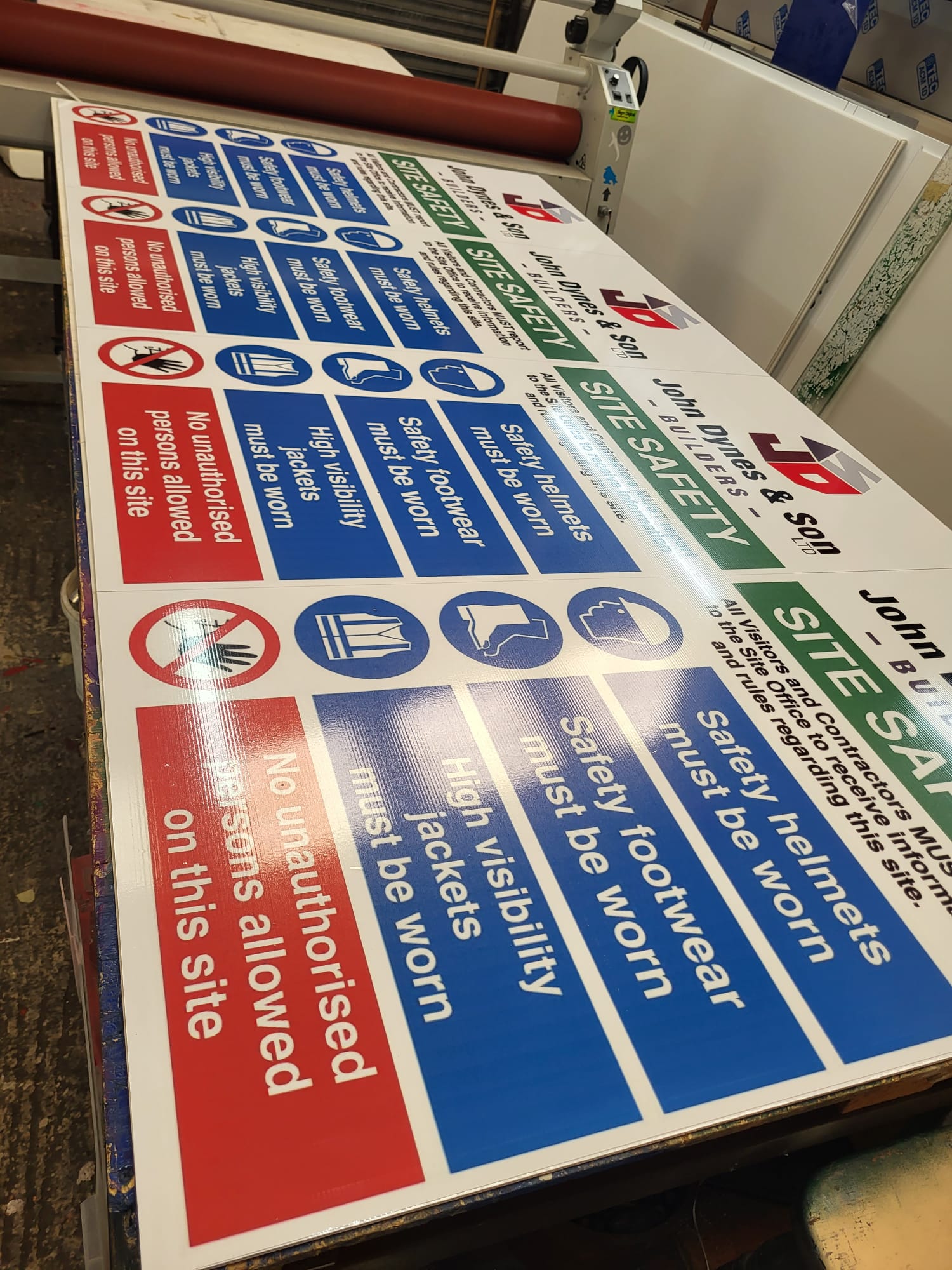 Branded site safety boards being laminated in the South Down Signs workshop in Newcastle, County Down
